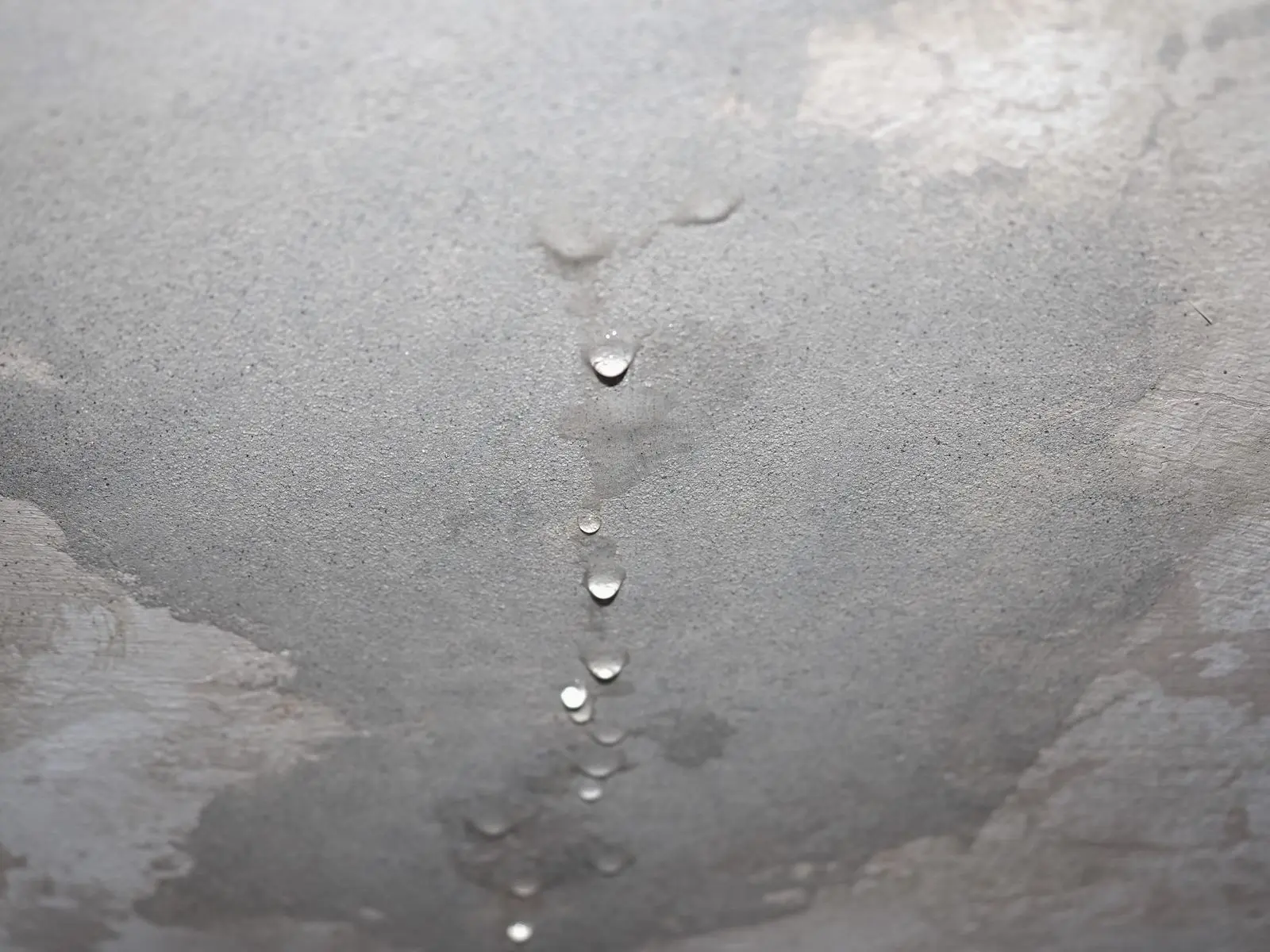 天花板滲水，水珠沿著水痕滴落